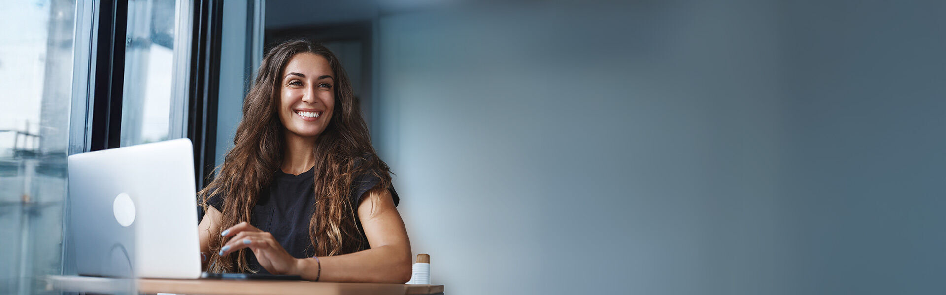 Junge Frau im Büro arbeitet konzentriert an ihrem Laptop.